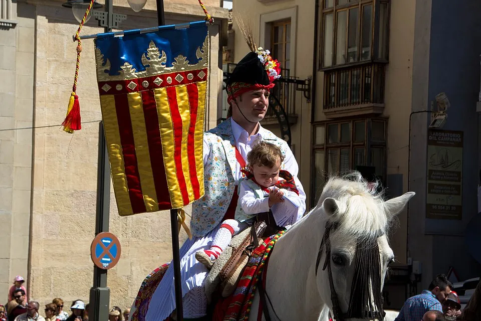 Cavaller amb senyera valenciana a la desfilada de Moros i Cristians